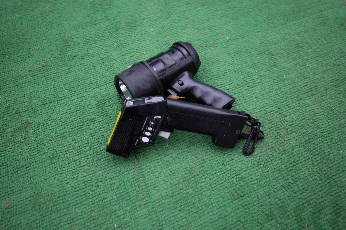 A flashlight and thermometer on green background