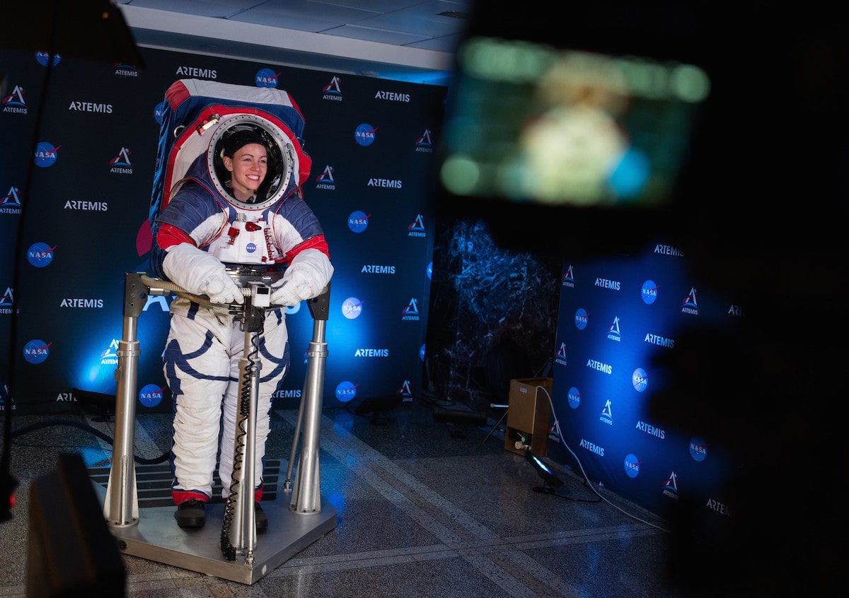 a woman astronaut stands in a new space suit