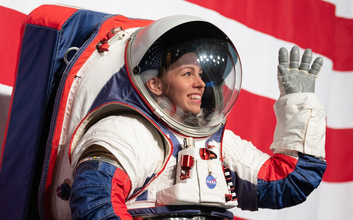 a woman astronaut in a space suit waving