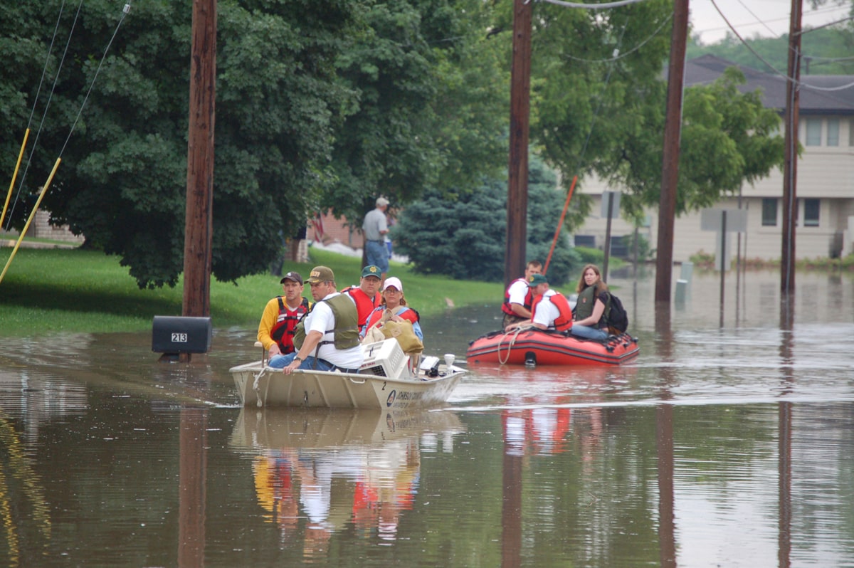 Personas en botes de rescate en una calle inundada