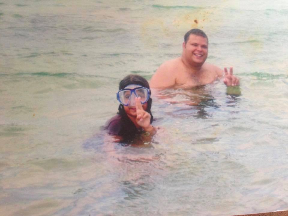 A girl and a man in the water on a beach