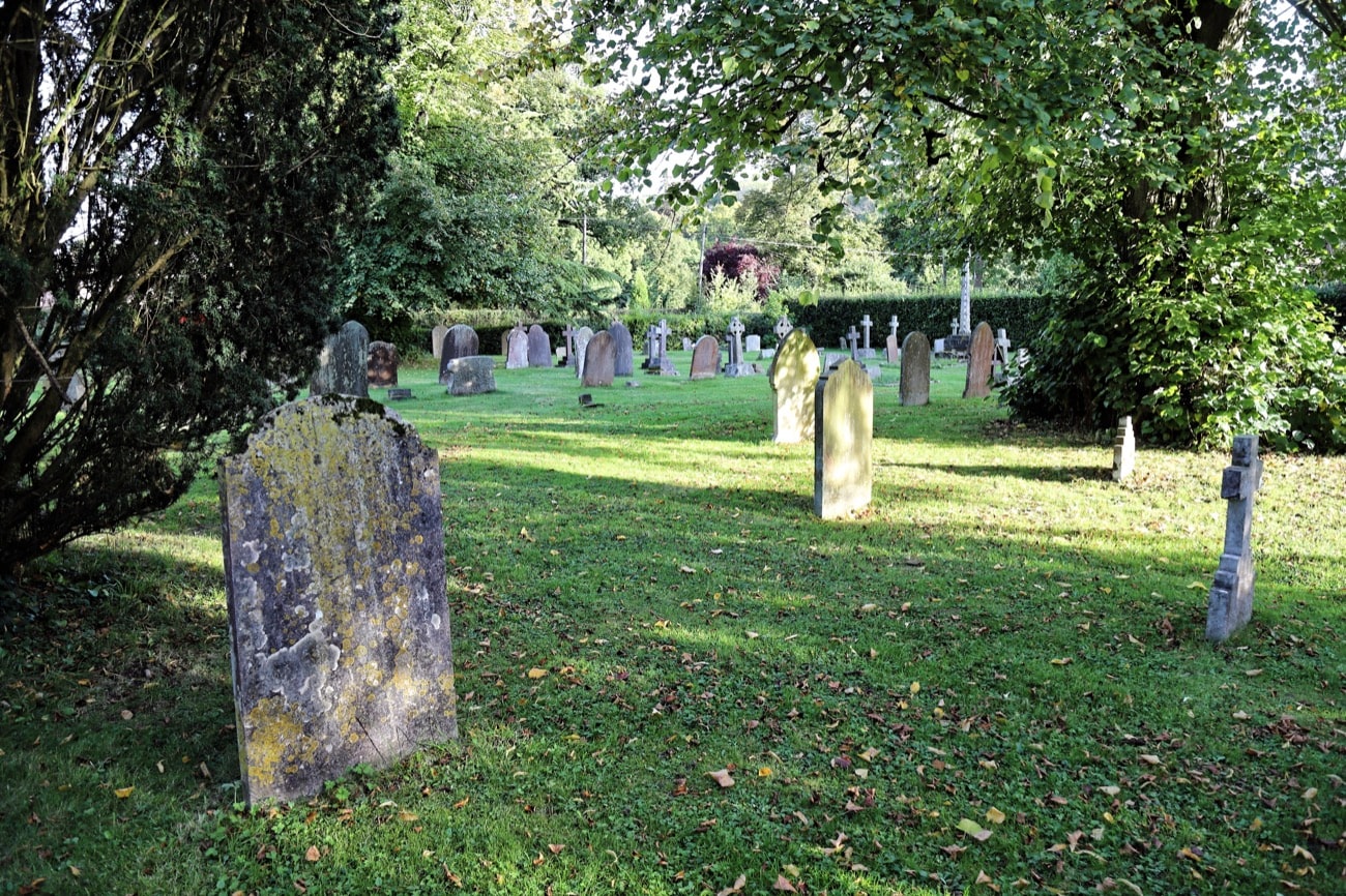 a graveyard with gravestones with lichen on them