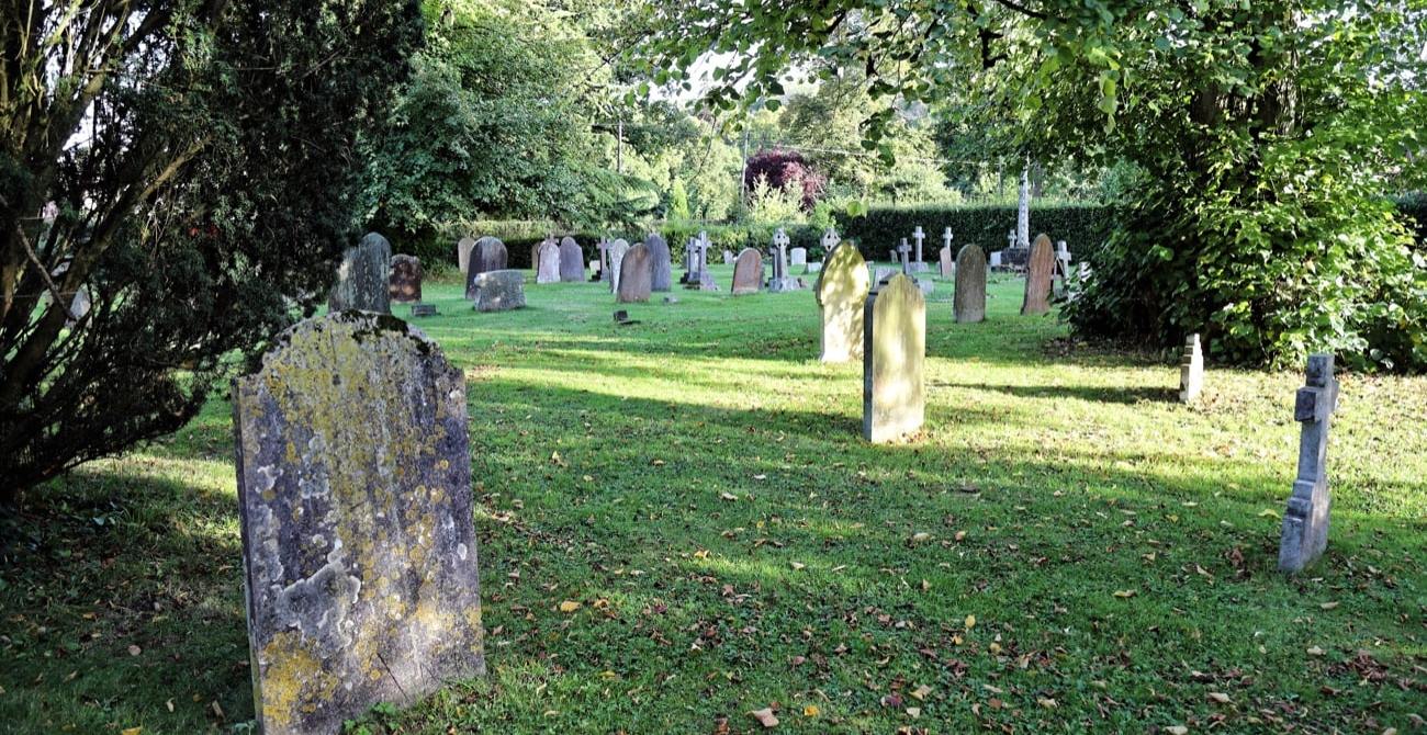 a graveyard with gravestones with lichen on them