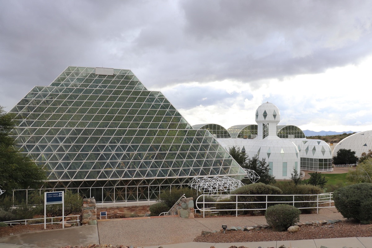 a futuristic structure with a large greenhouse-like feature that's filled with a rainforest