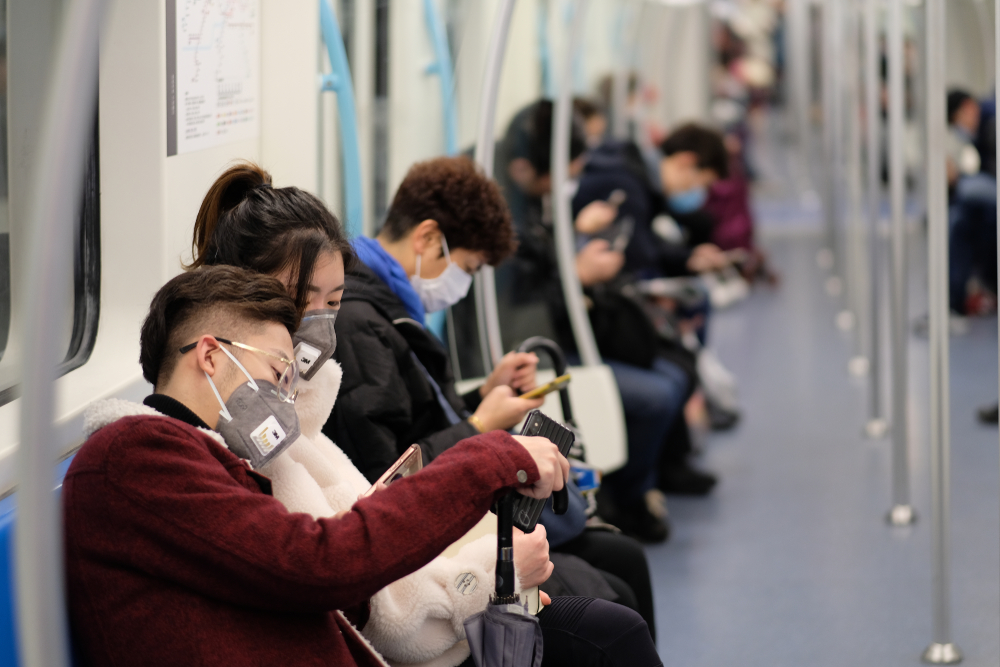 people in china on a subway train. everyone is wearing medical masks