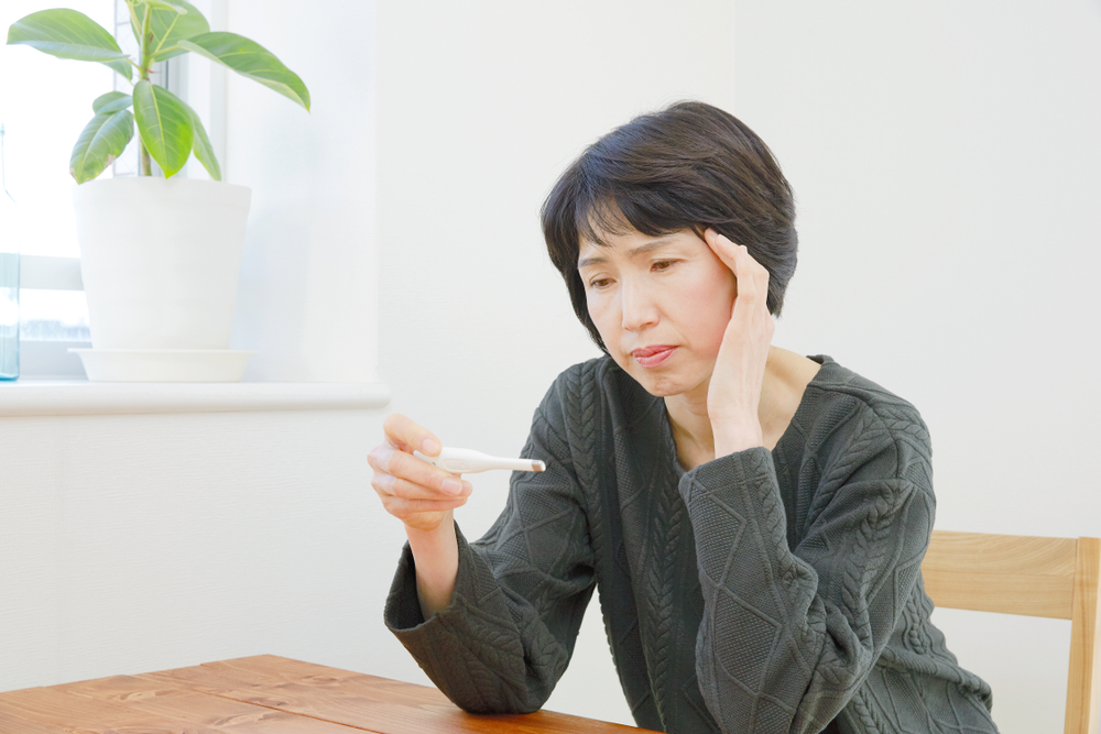 a woman looking at personal thermometer