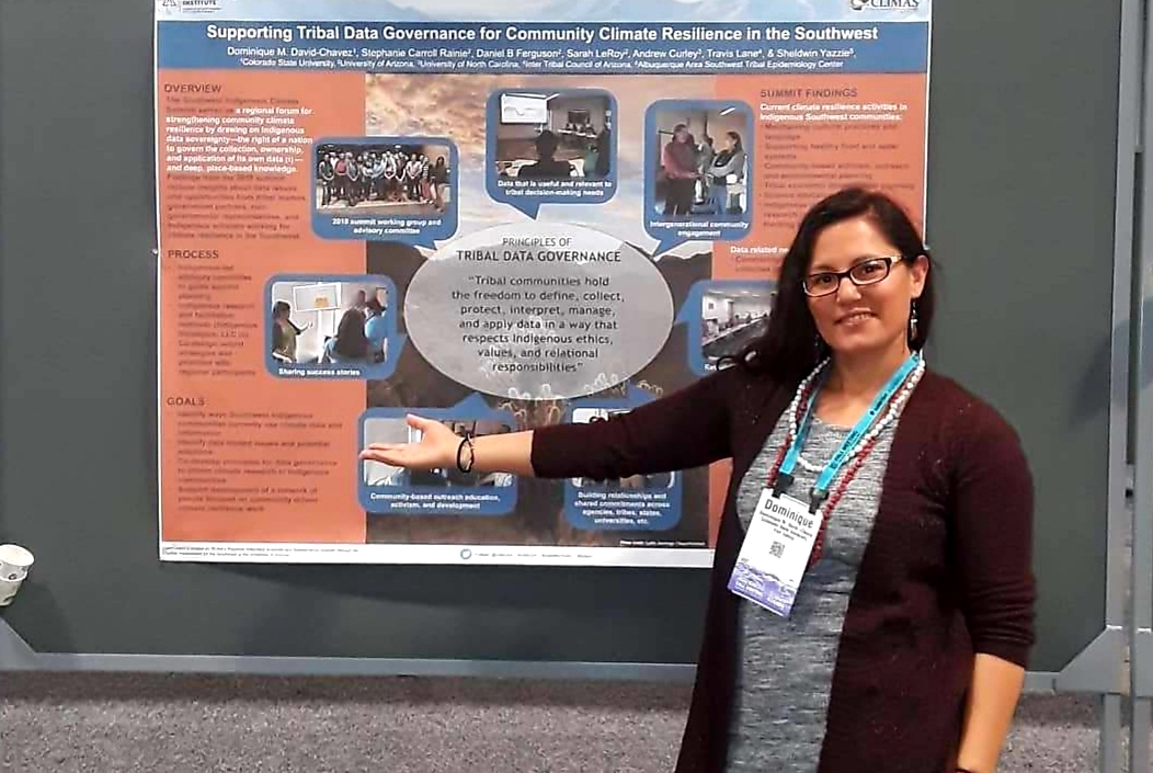 a woman stands in front of a scientific poster