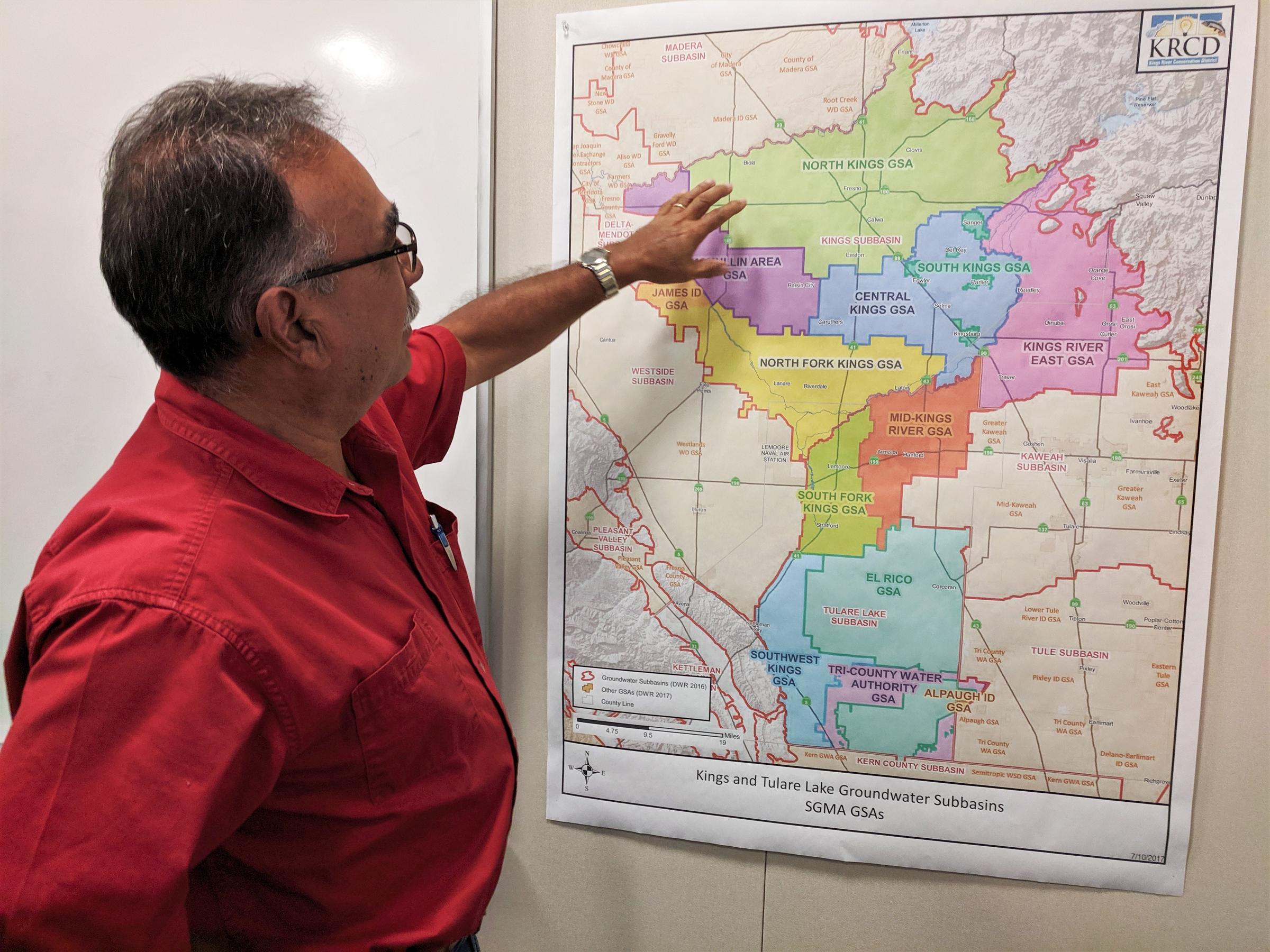 a man gestures to a colored map