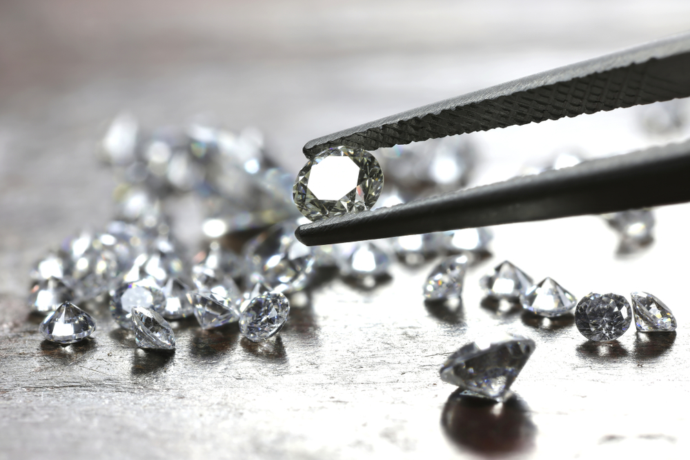 brilliant cut diamond held by tweezers