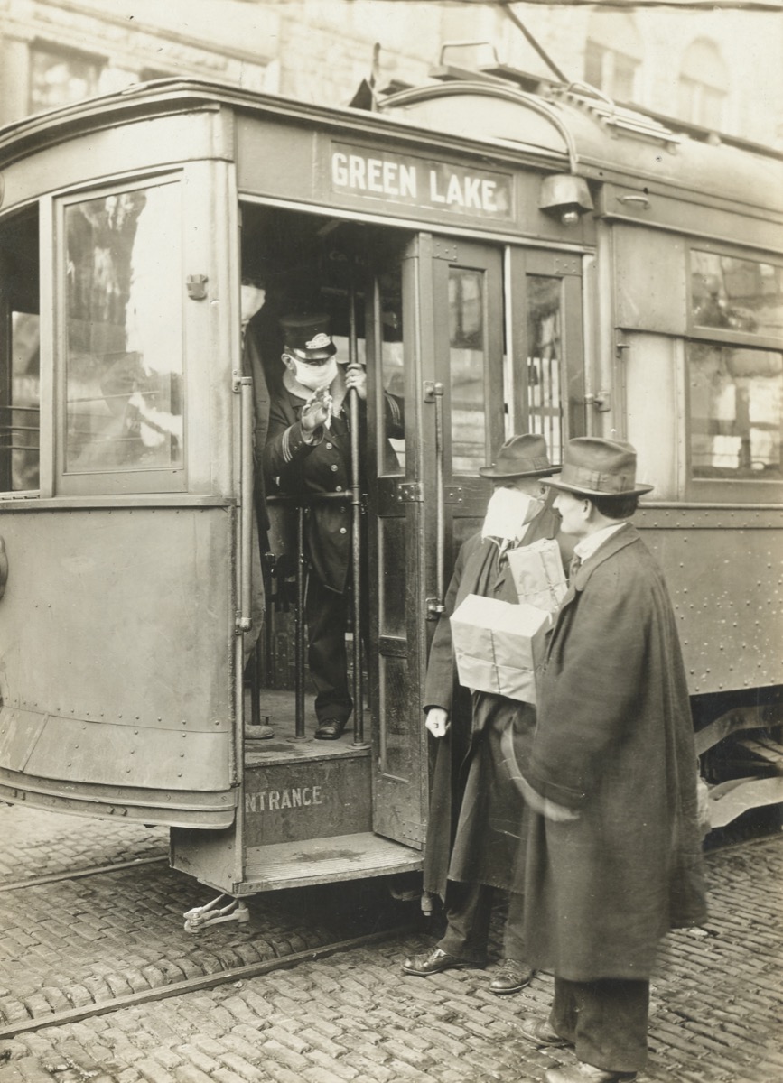 a street car conductor wearing a face mask stops a passenger from trying board who wasn't also wearing a mask