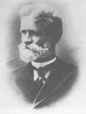 a black and white photo of a man with a large, santa claus-y beard/mustache combo