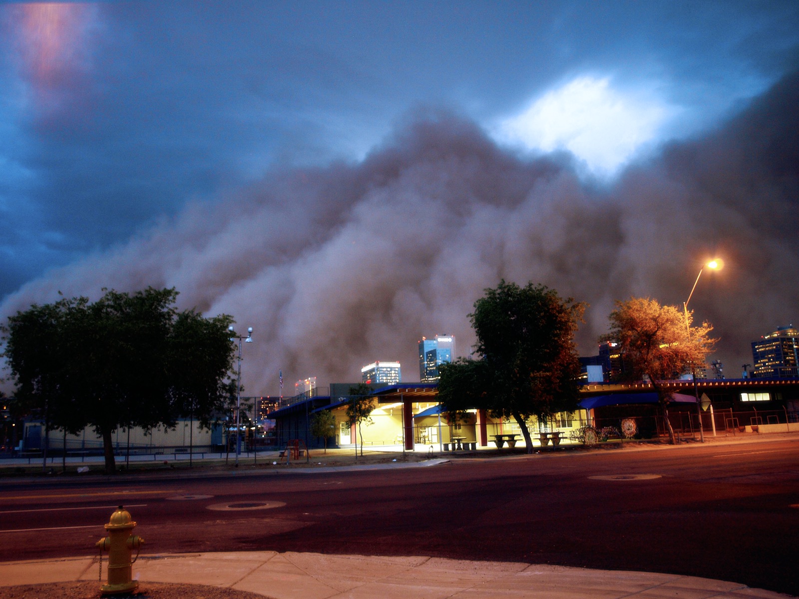 a huge wall of dust rolls over a city