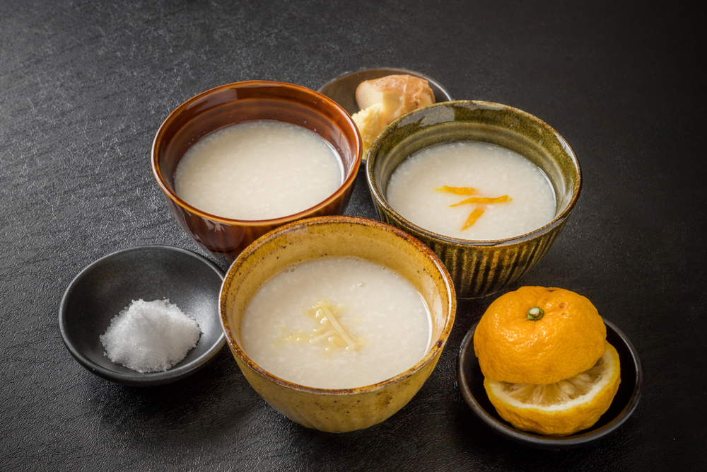 three bowls of a white liquid, with a smaller bowl of salt and another with an orange