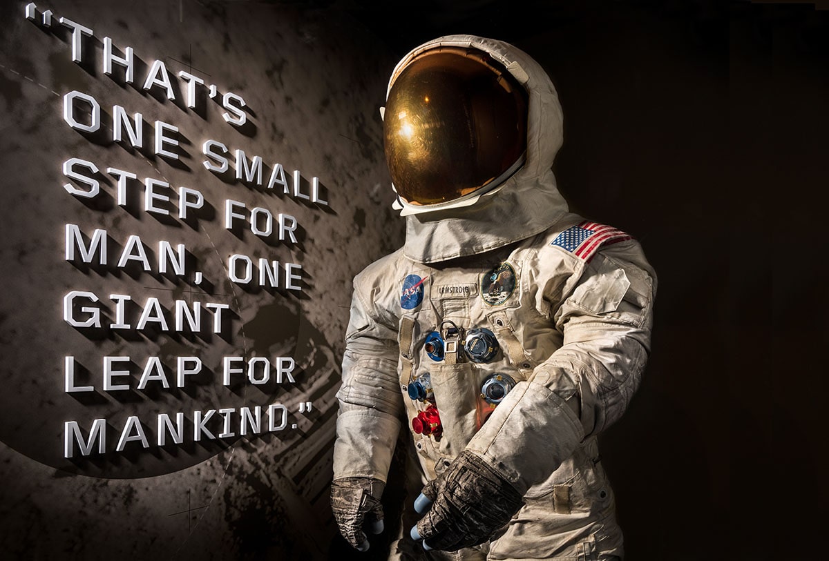 To the left writing "THAT'S ONE SMALL STEP FOR MAN, ONE GIANT LEAP FOR MANKIND" next to a space suit used during the Apo