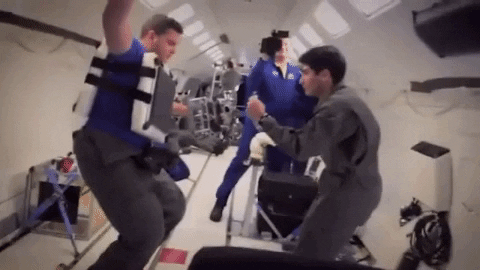One researcher attaches gripper to another researcher to test it in zero gravity.