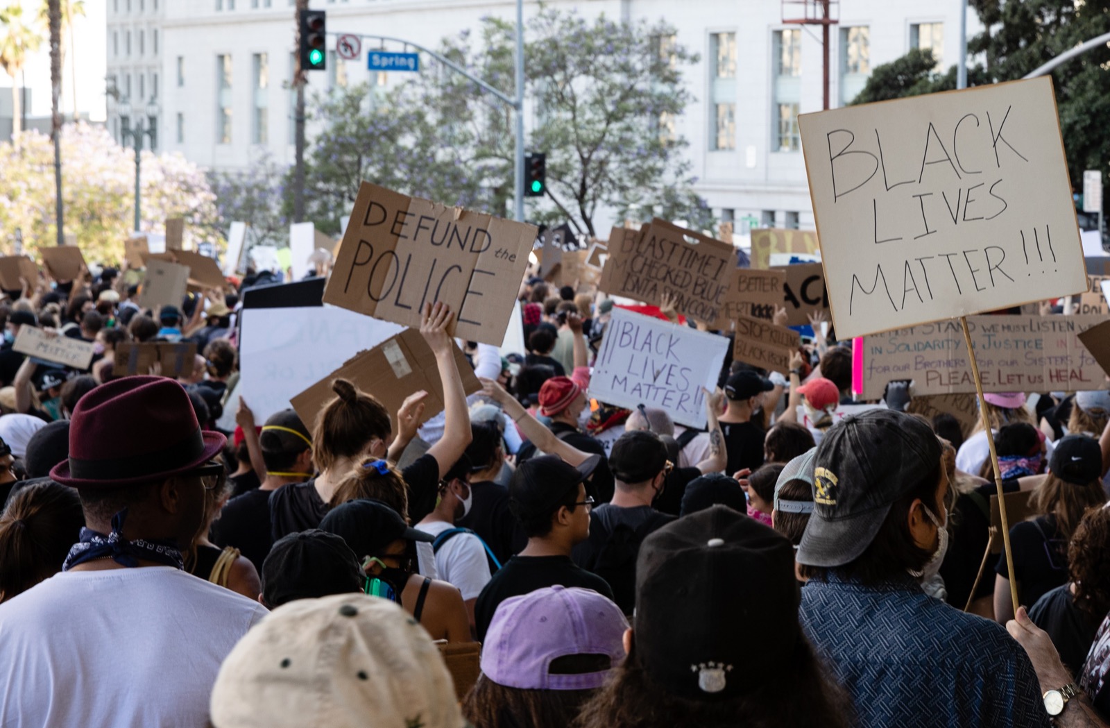 hundreds of people at protest with signs that say "black lives matted, defund the police"