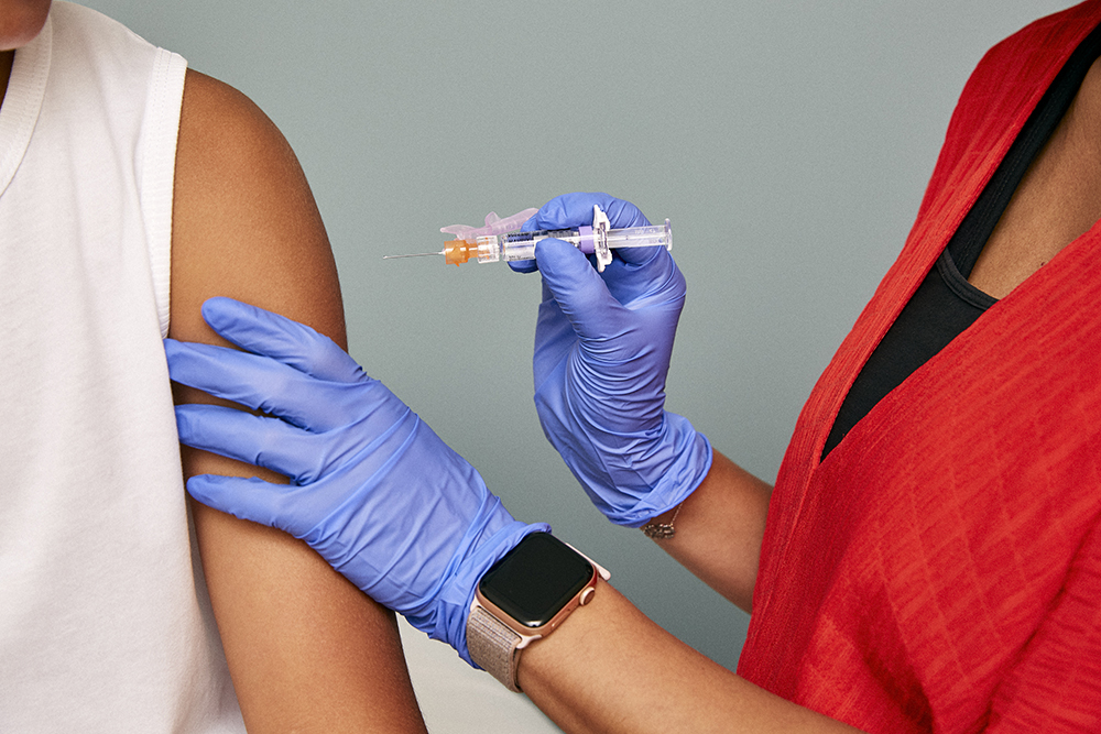 a doctor giving a patient a shot in the shoulder