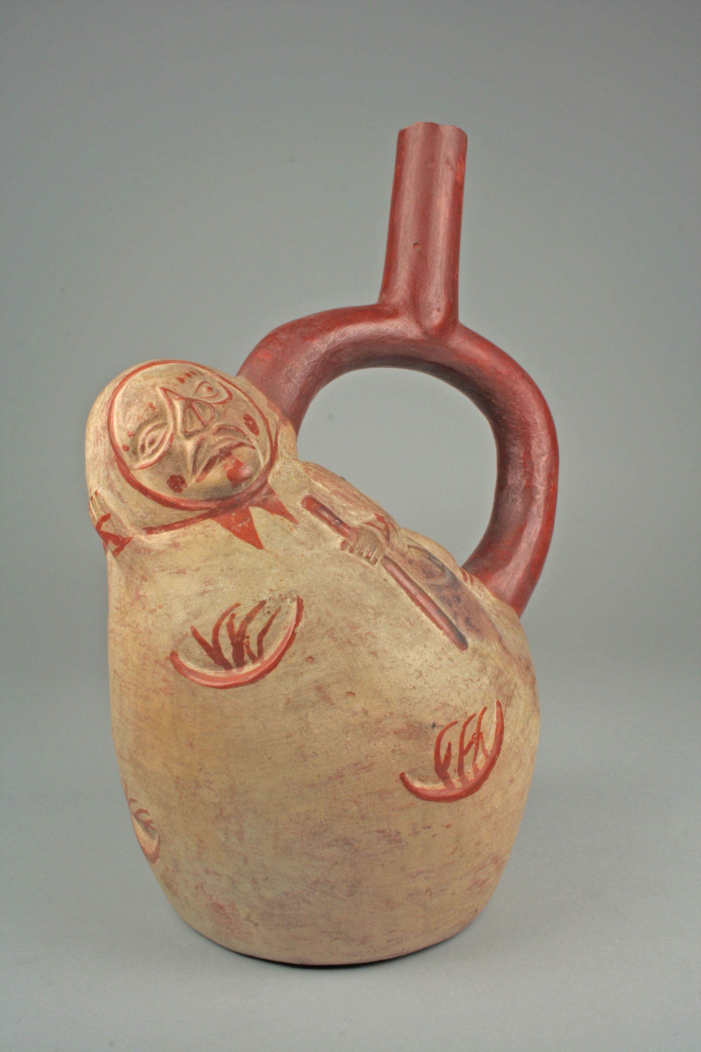 an old ceramic jug that resembles a potato with a handle sticking out. the potato jug is anthropomorphized, with a head that has a stern looking face at the top and a hand holding a staff painted on the "body"