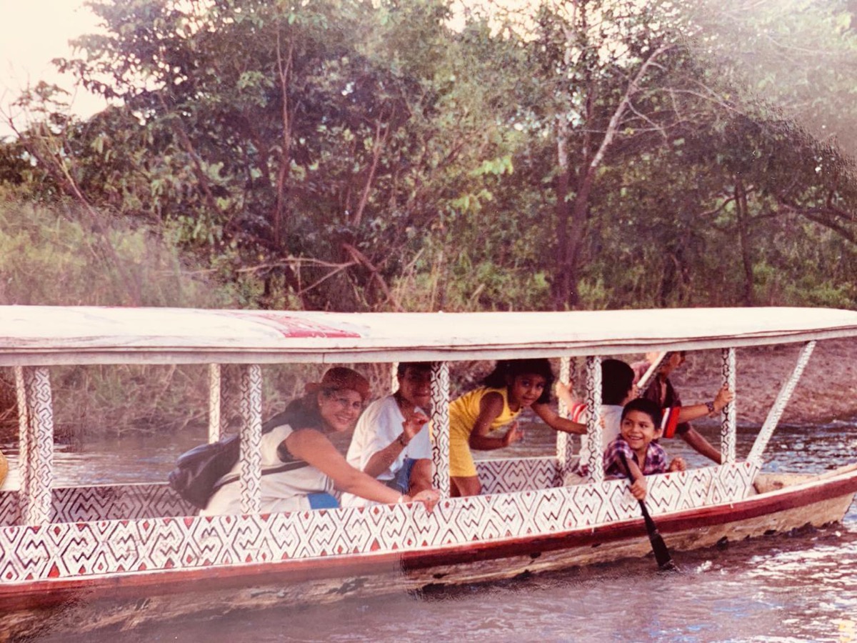 an old photo of a family rowing on a boat in the amazon jungle