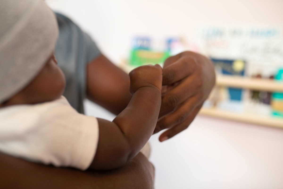 a black parent and baby hold hands