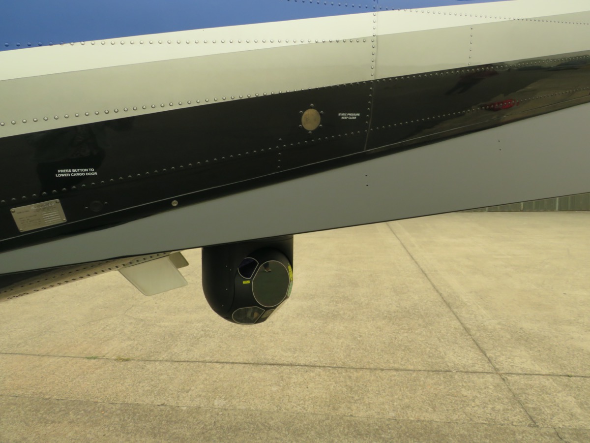 a small black camera attached to the wing of a plane