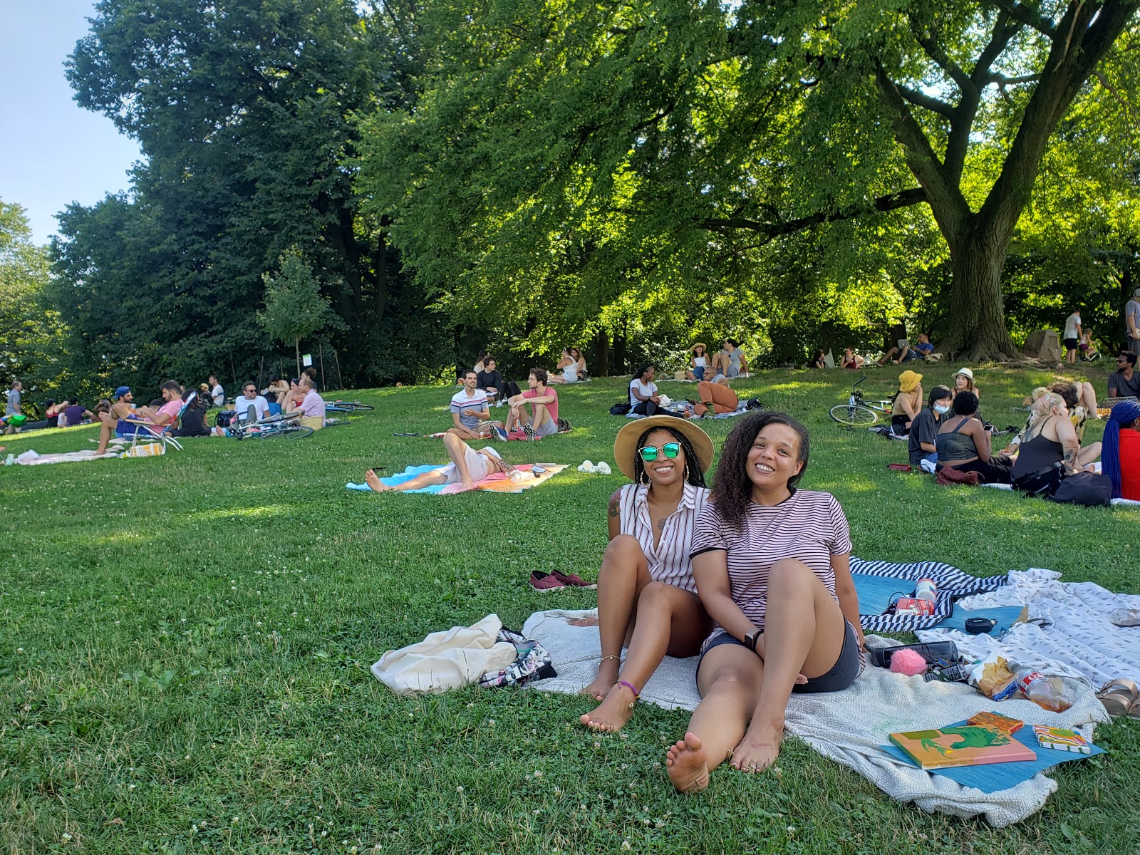 two people smiling at camera on grass in park