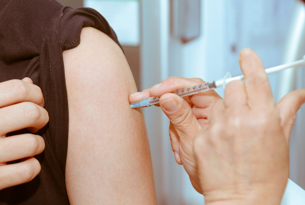a doctor giving a vaccine shot to a patient in the arm