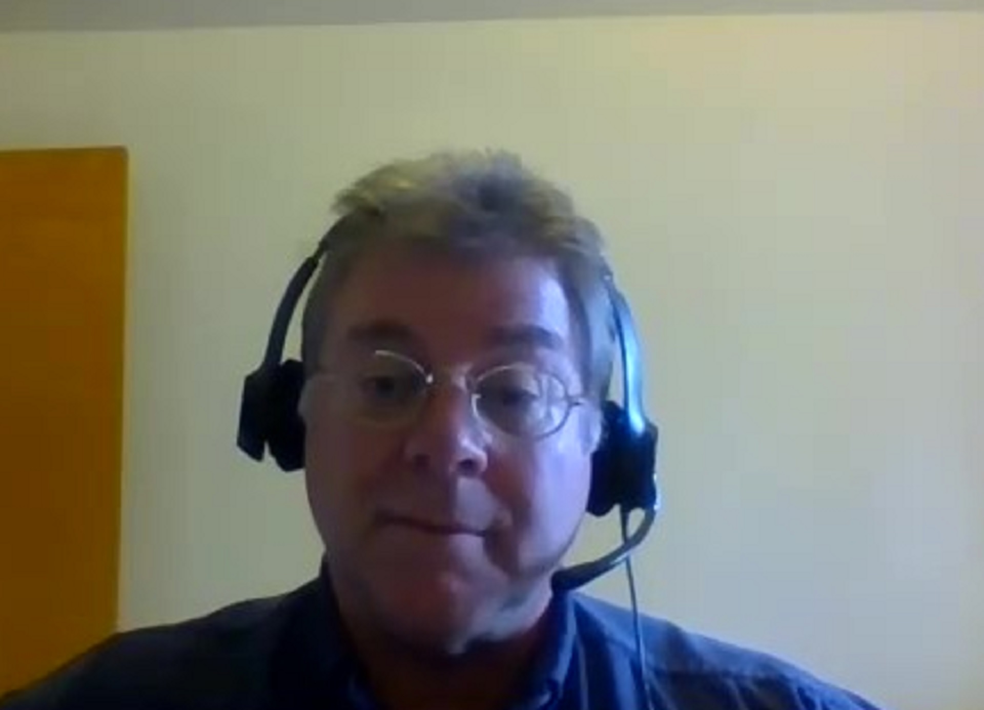 a video chat screenshot of an Asian man wearing a headset