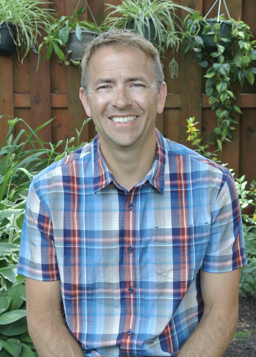 a profile photo of a man in a plaid shirt