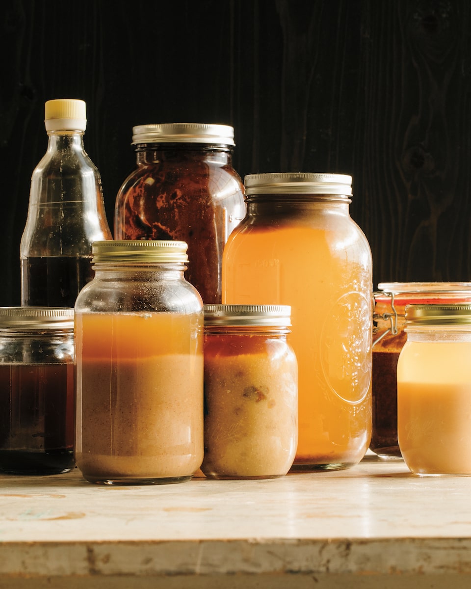 an assortment of jars with various colored liquid sauces made from koji inside