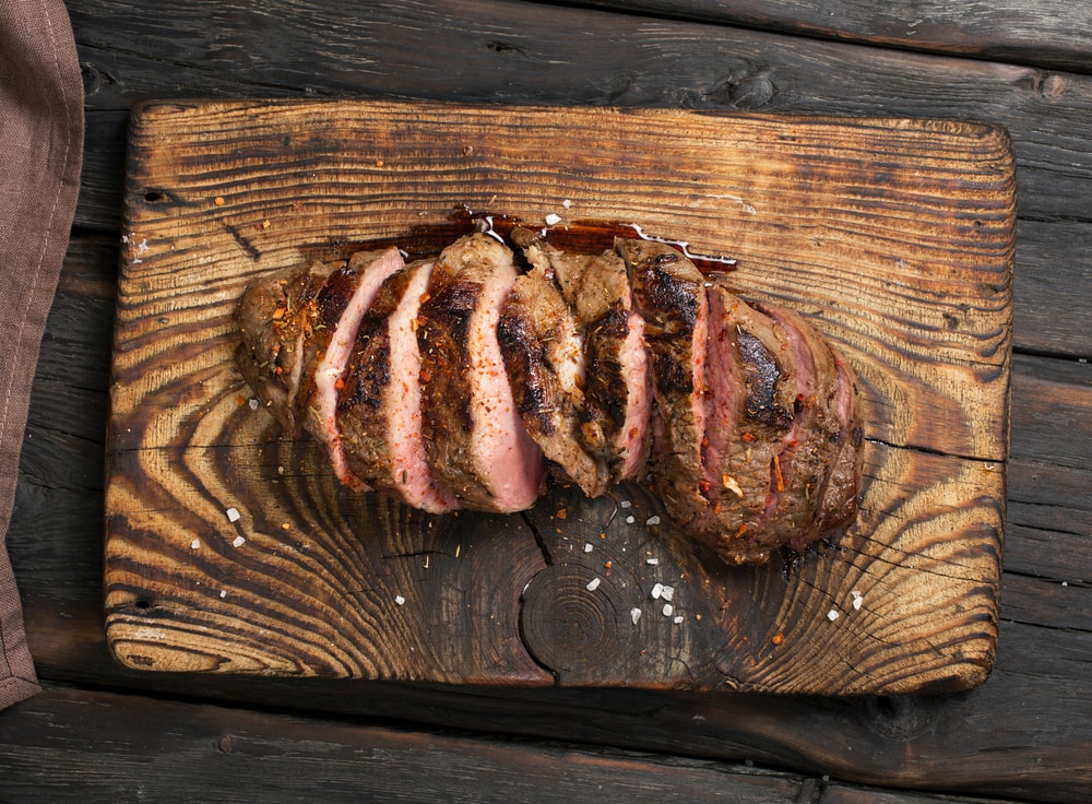 cooked beef cut up on cutting board