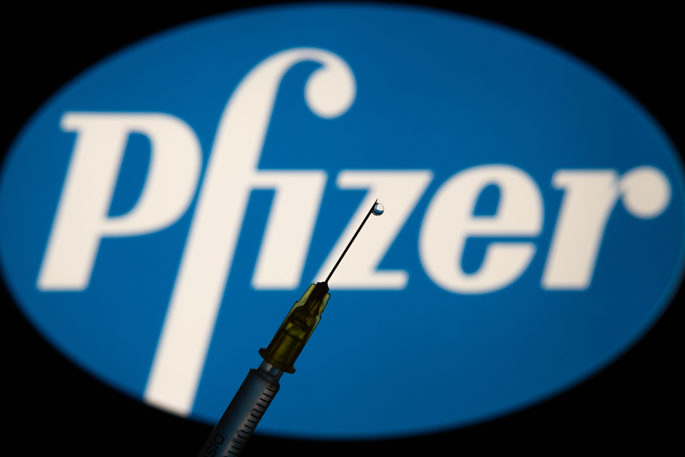a needle with the pfizer logo behind it