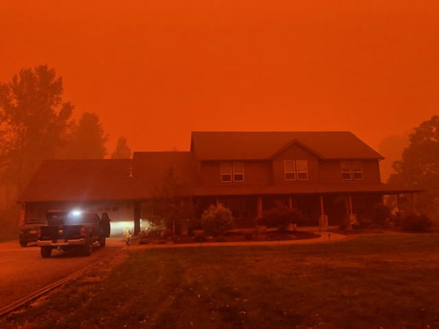 a home doused in a scary red glow cast from the smoke from wildfires in oregon