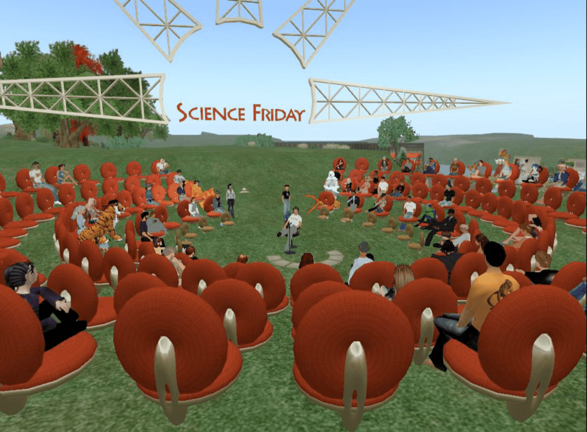 a virtual world from the late 2000s, showing an ampitheater of avatars arranged in a circle on an island. in the background is a big scaffolding structure of a sun and the science friday logo