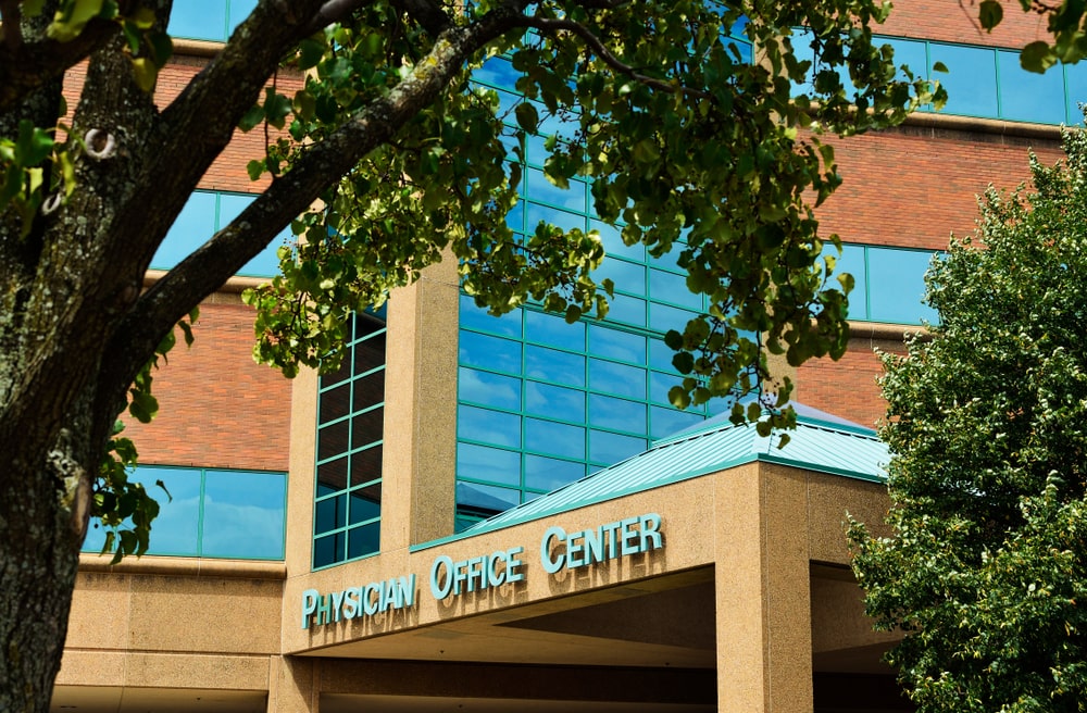 the exterior of a hospital building, flanked by trees