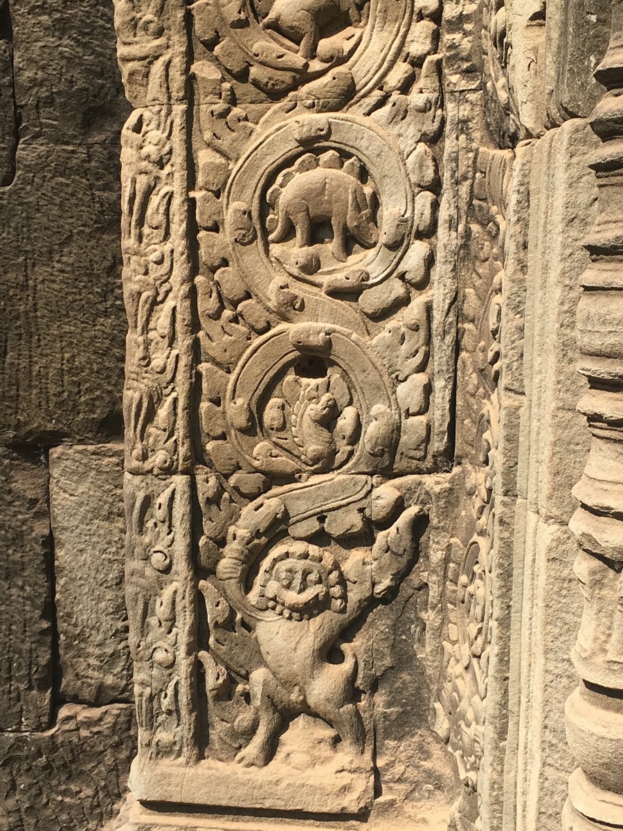 an intricately stone carved wall with various creatures and designs. 