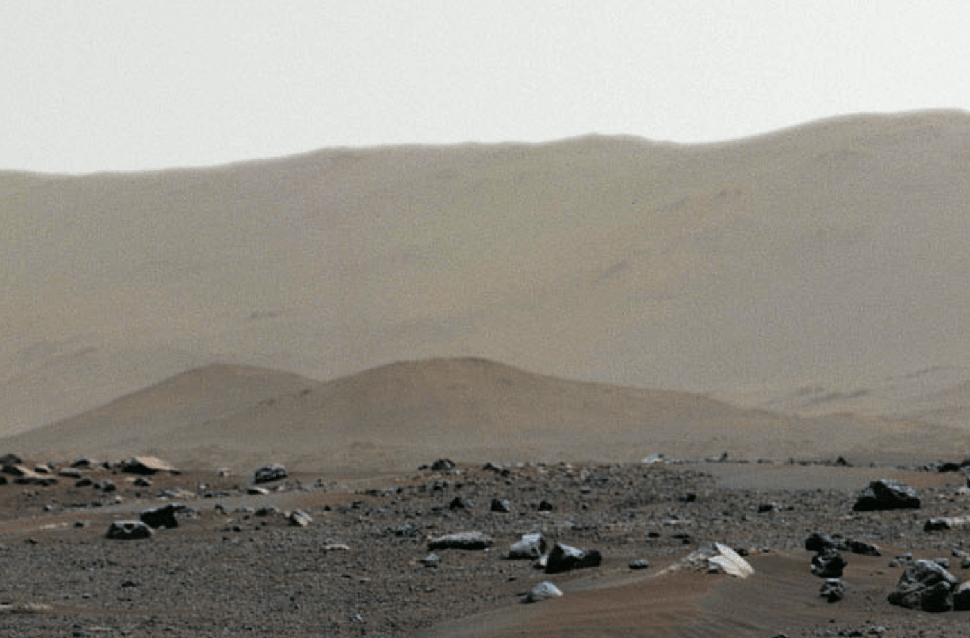 a martian landscape showing a rising hill in the distance