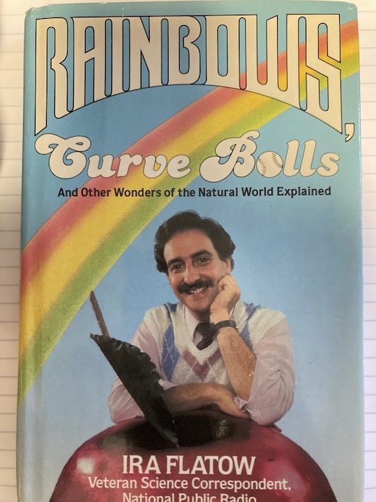 a vintage book cover of a man with a moustache and propped up on an apple. on the cover is a rainbow above him with the title "rainbows: curve balls and other wonders of the natural world explained"