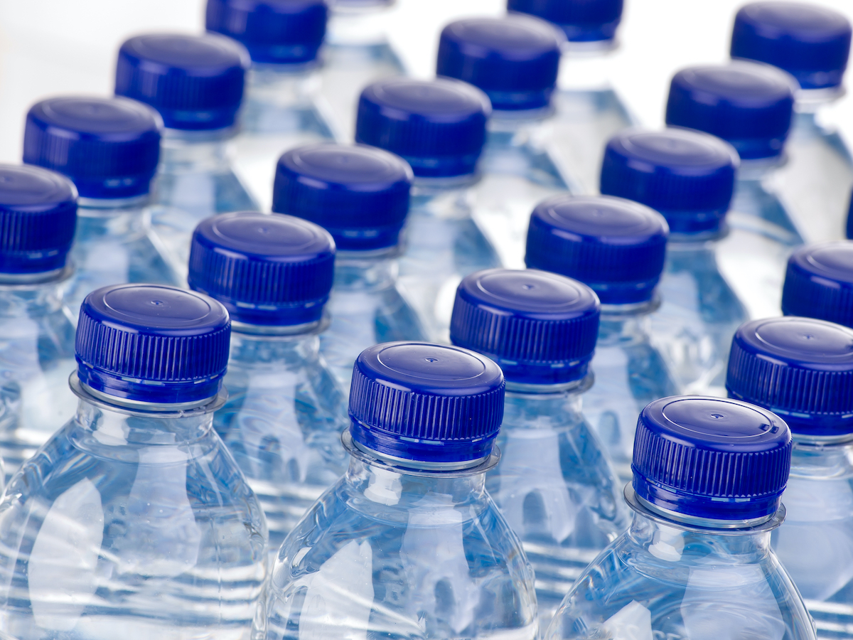 close up of rows of blue plastic water bottles with dark blue caps, all closed