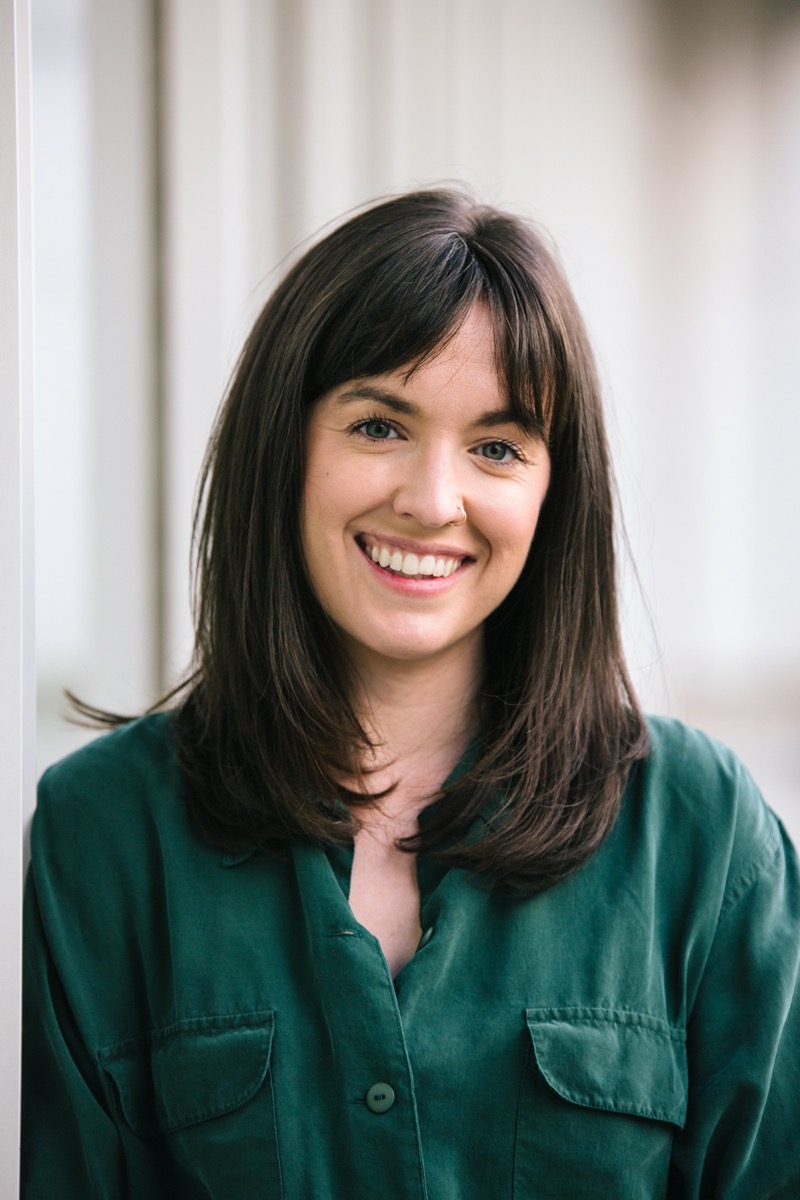 a professional headshot of a woman with brown hair wearing a green shirt