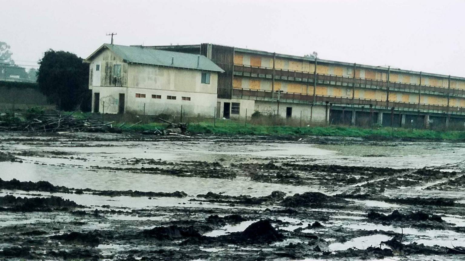 industry buildings and sheds flooded by murky muddy water