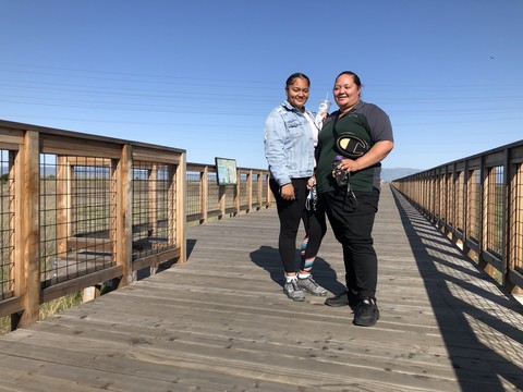 two woman standing on a pier