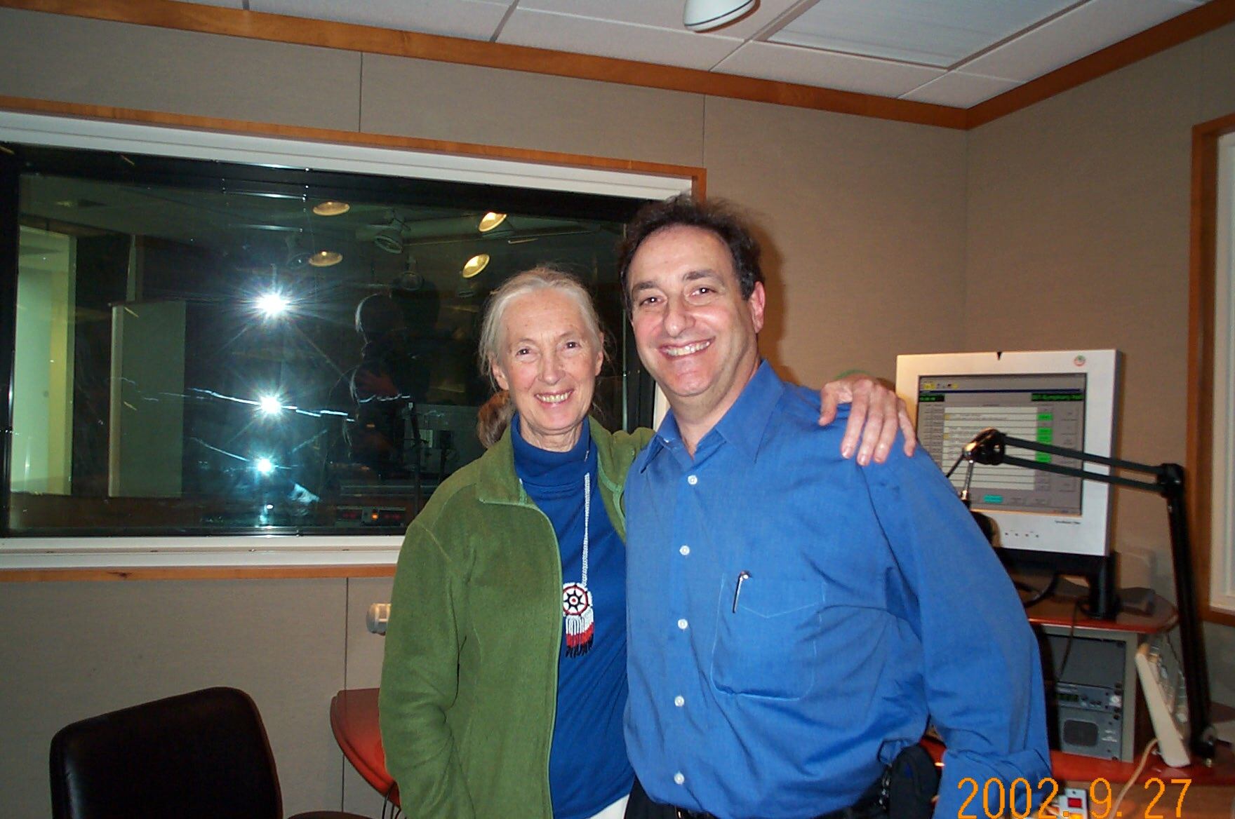 an older woman and man smiling together in a radio studio