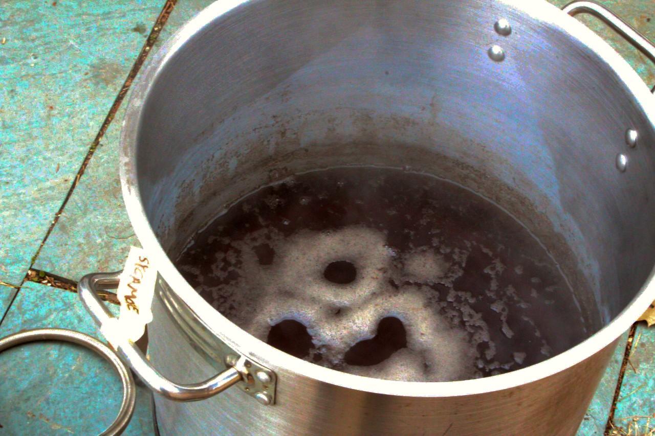 a stainless steel pot barely filled with syrup