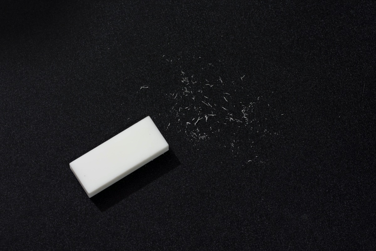 white eraser with scraps against a black background