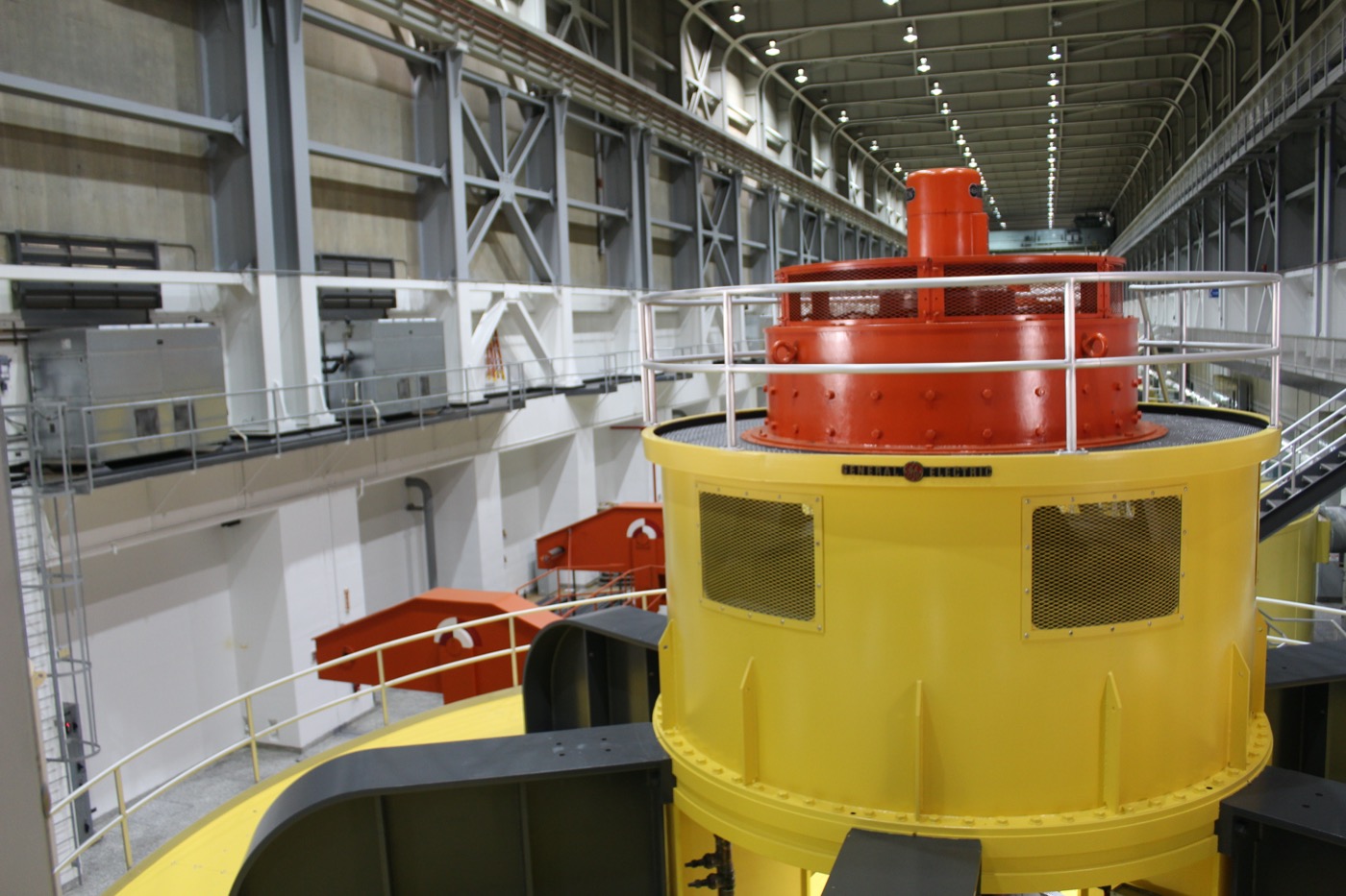 an interior of a large industrial building, with a large cylindrical machine in the foreground