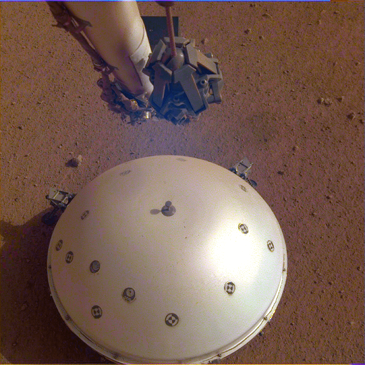 a robotic arm above a white dome structure on a red earth landscape