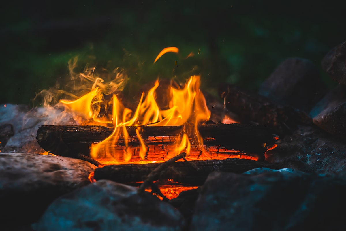 Close up of a campfire with orange flames.