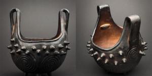 Cherokee firepot with two looped handles. Black on the outside with cone protrusions along the rim.