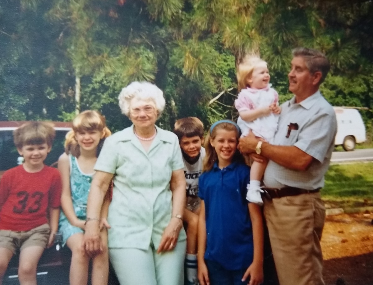 an old film camera picture of a family. two grandparents are flanked by their grandchildren